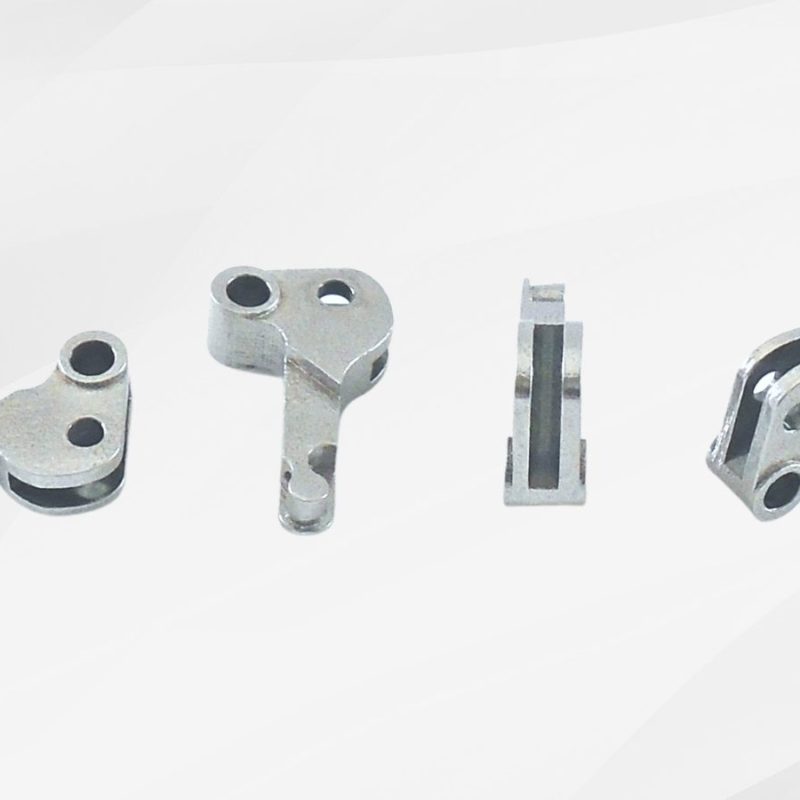 Four metal mechanical parts are arranged in a line on a white background, showing different angles and cuts of the components.
