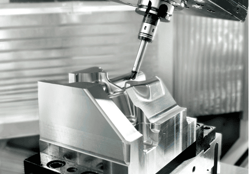 A CNC machine tool precisely mills a complex metal part in a manufacturing setup.