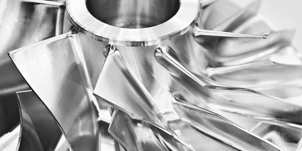 3DEO Launches 316L Stainless Steel in High-Volume Metal 3D Printing Close-up of a metallic turbine blade crafted using 316L stainless steel 3D printing, showcasing shiny, curved surfaces and intricate details.