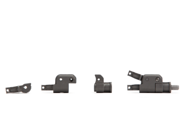 Four black metal components, varying in size and shape, are aligned horizontally against a white background, reflecting quality craftsmanship to aid assembly simplification.